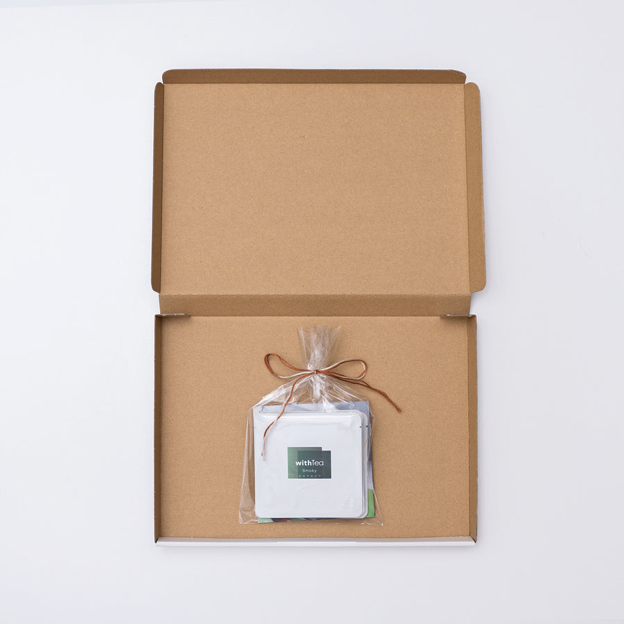 withTeaの商品「テイスティングセット - 和紅茶」が発送された時の状態です。箱のなかに、お茶が３袋とパンフレットがビニール袋に包まれて入っています。